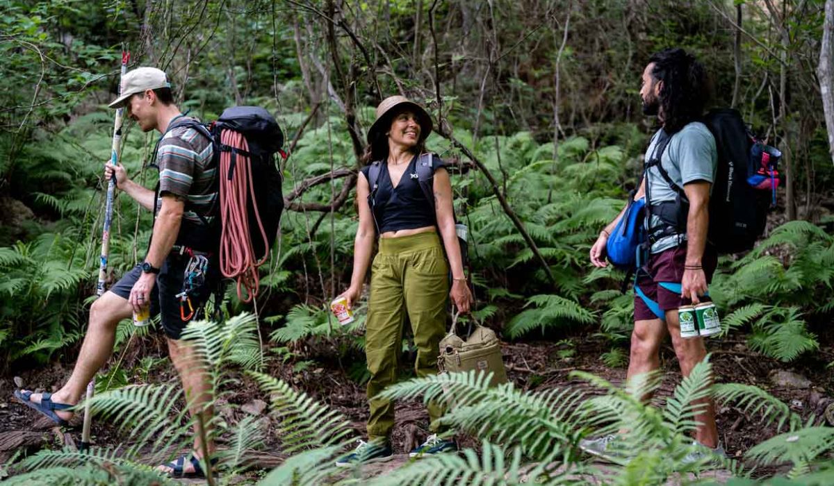 Three people hiking with howdy beverages in hand