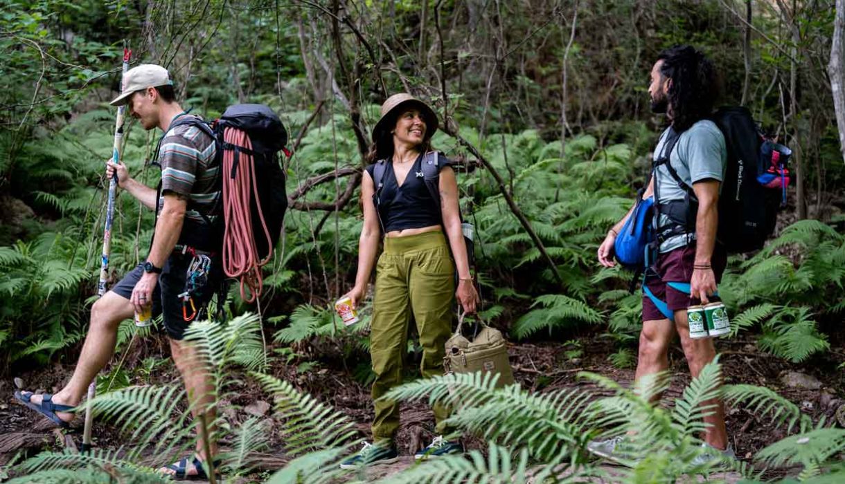 Three people hiking with howdy beverages in hand