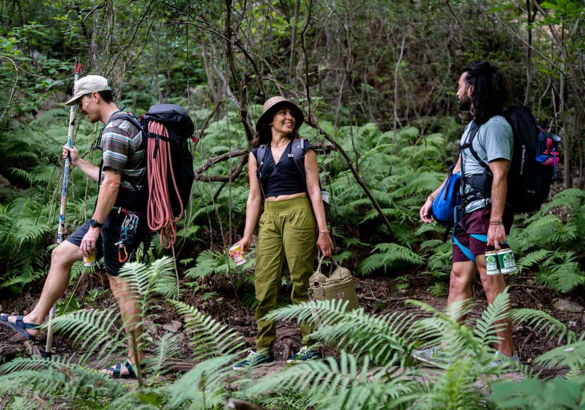 Three people hiking with howdy beverages in hand